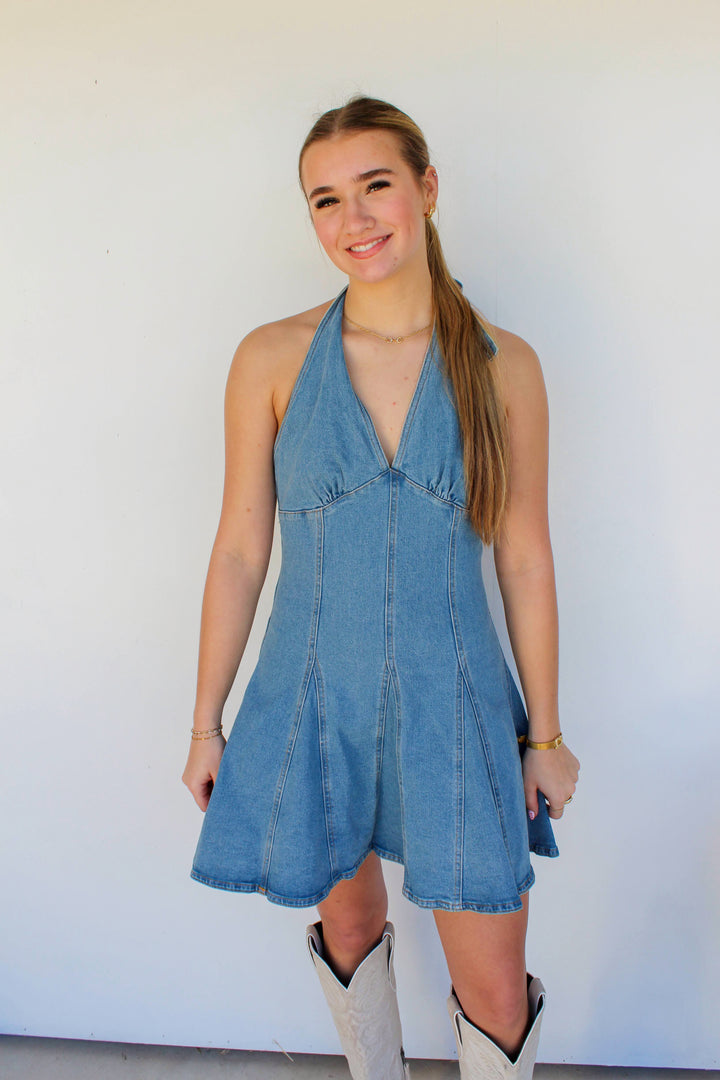 Woman wearing a blue denim dress against a white background